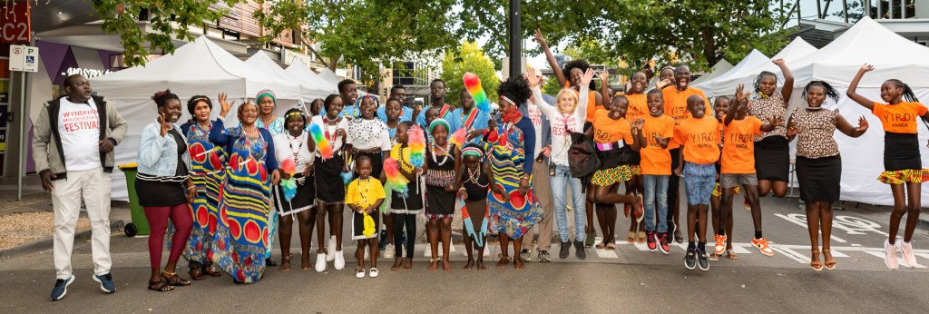 Photo of members of the Wyndham community - some in cultural dress - jumping in the air. 