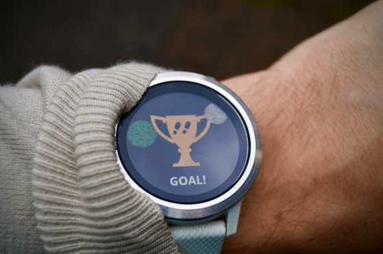 a close up of a person's wrist with a watch on it. Activity Tracker text: Goal!